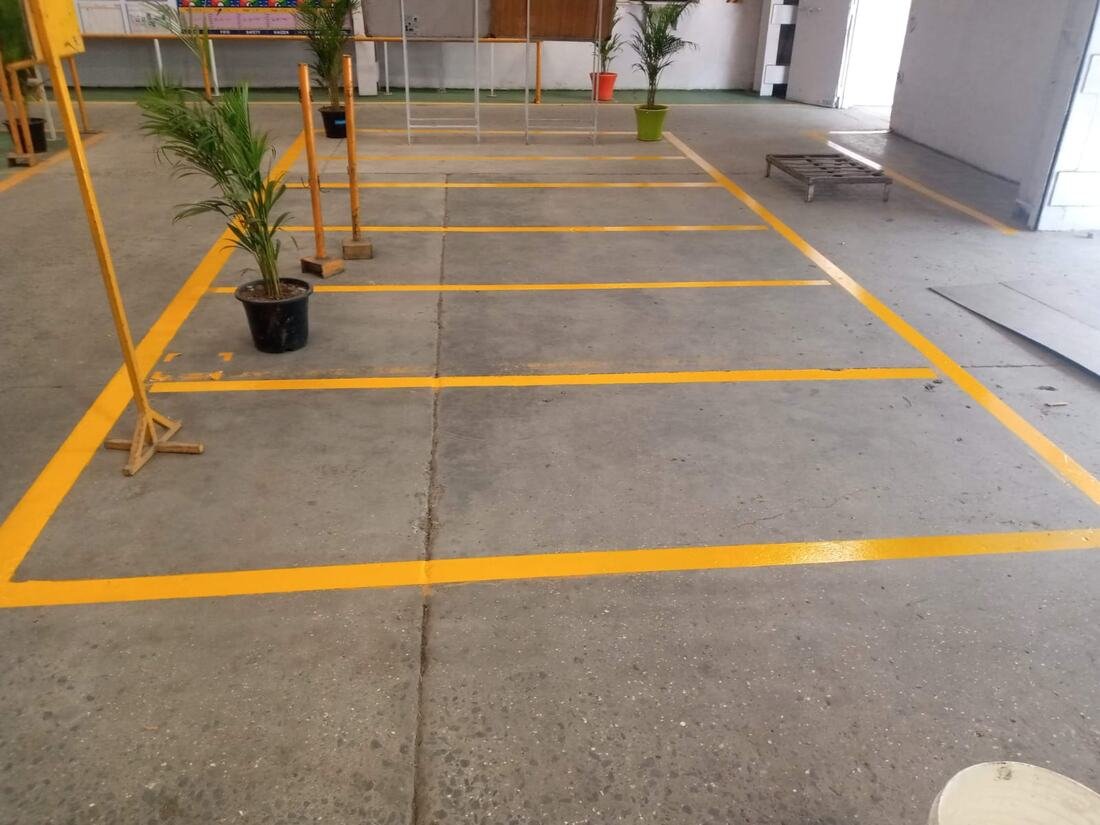 Yellow warehouse floor marking lines around potted plants