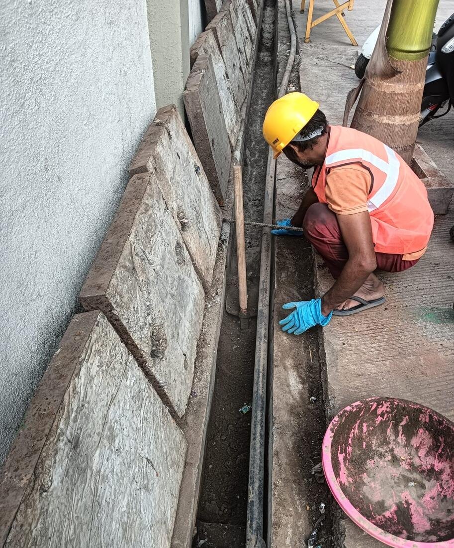 IFS worker carrying out waterproofing and civil work along a boundary wall